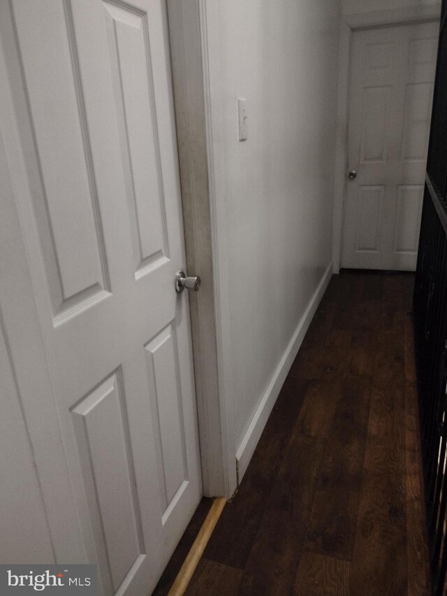 corridor with dark hardwood / wood-style flooring