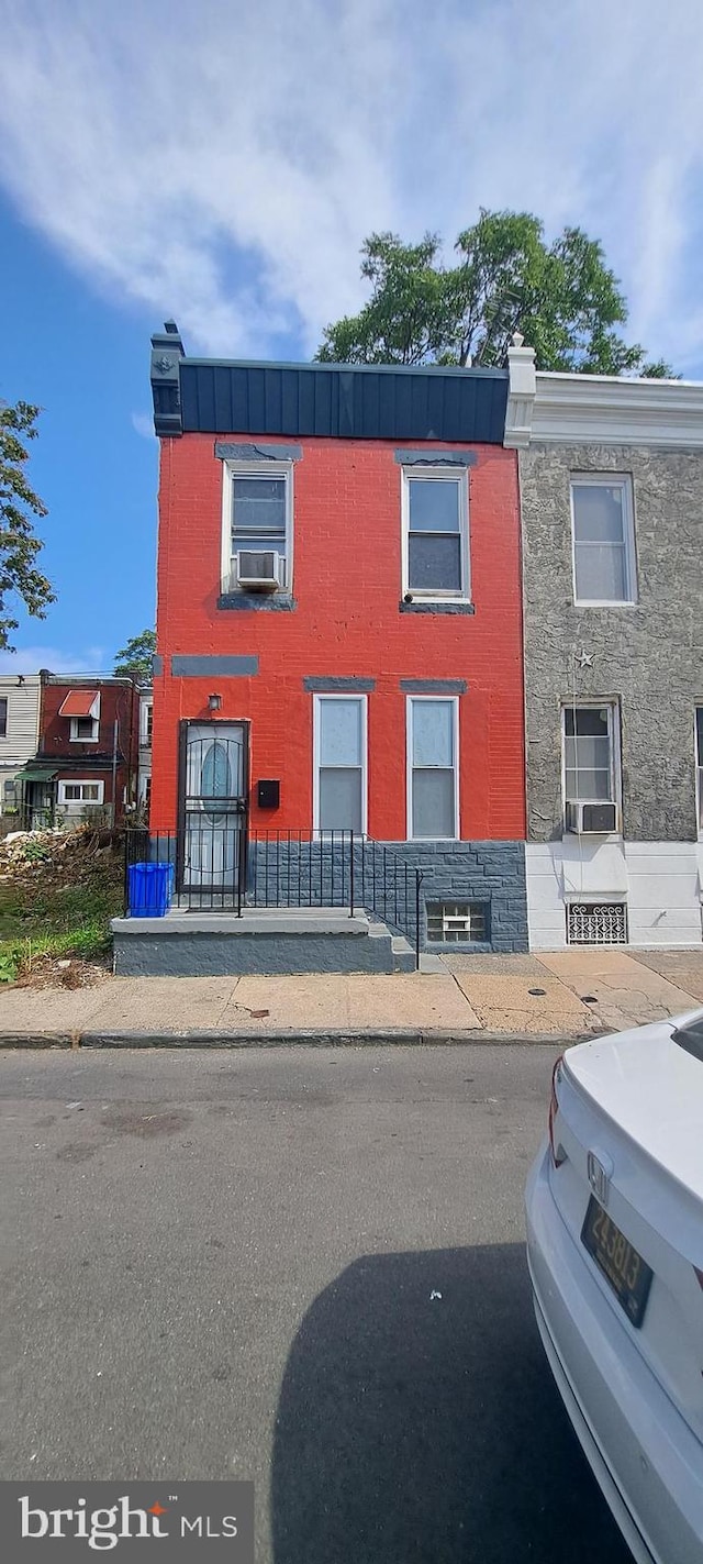 view of property featuring brick siding and cooling unit