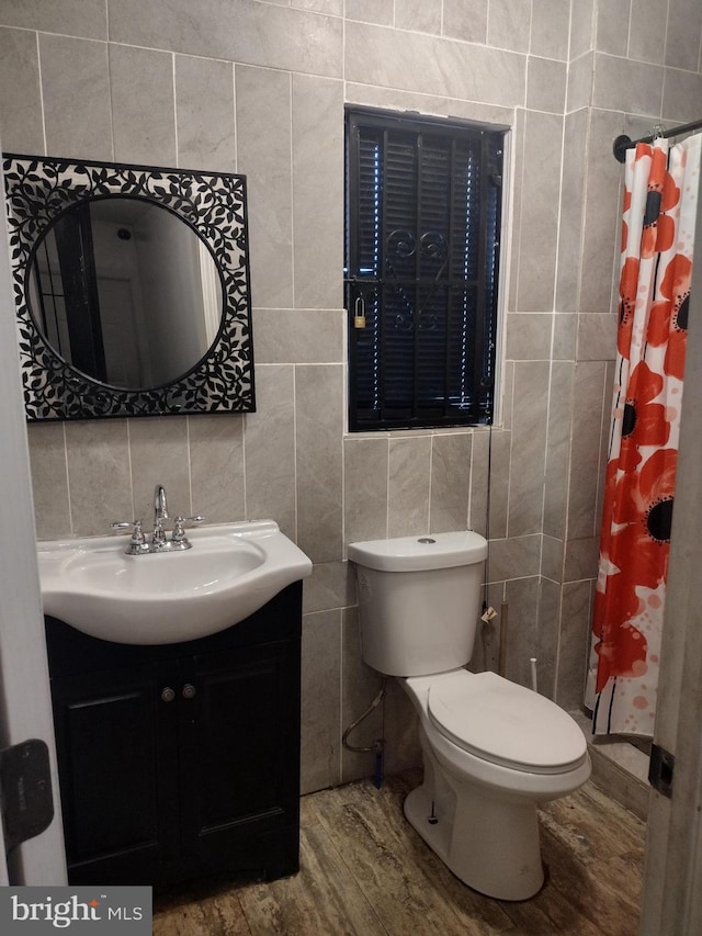 bathroom with tile walls, curtained shower, vanity, wood-type flooring, and toilet