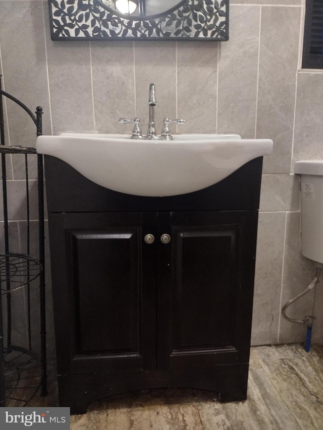 bathroom with vanity, tile walls, and hardwood / wood-style flooring