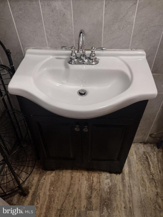 bathroom featuring tile walls, vanity, and hardwood / wood-style flooring