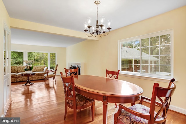 dining space featuring light hardwood / wood-style flooring and a notable chandelier