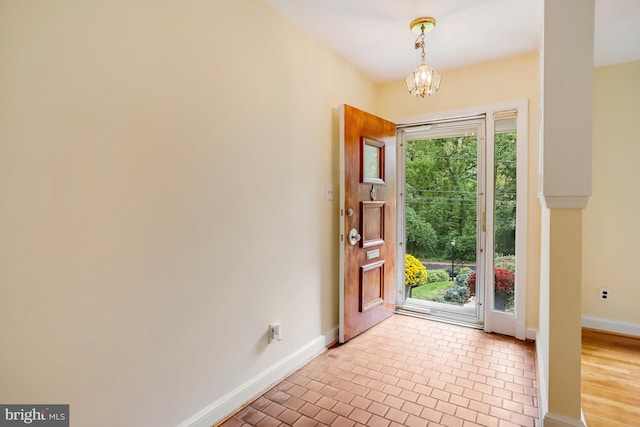 entryway with light wood-type flooring and an inviting chandelier