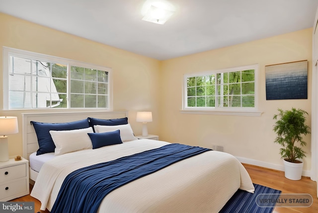 bedroom with wood finished floors, baseboards, and visible vents