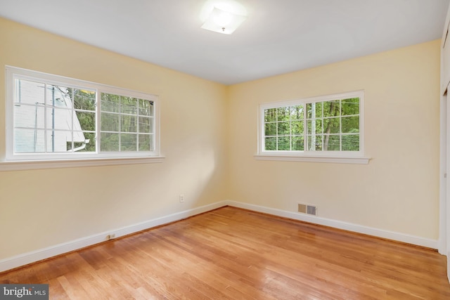 spare room featuring light wood-style flooring, baseboards, and visible vents