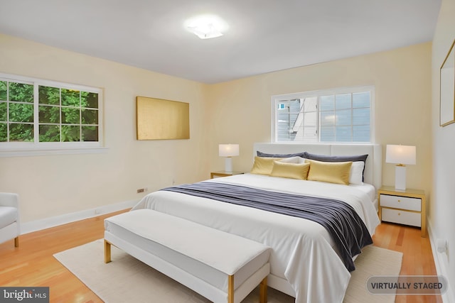 bedroom with baseboards and wood finished floors
