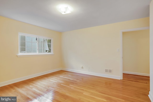 unfurnished room with light wood-style flooring, baseboards, and visible vents