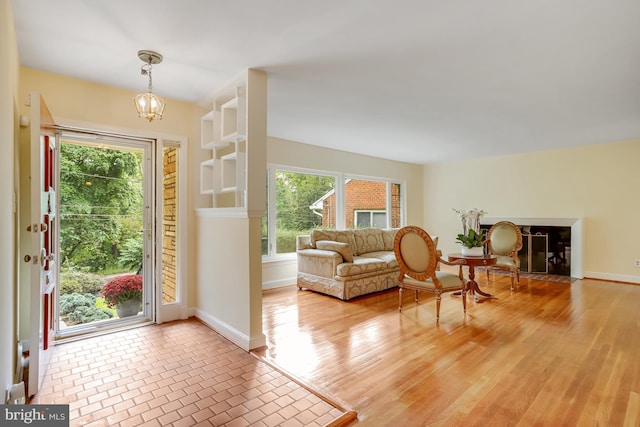 entrance foyer with light wood finished floors, a notable chandelier, and baseboards