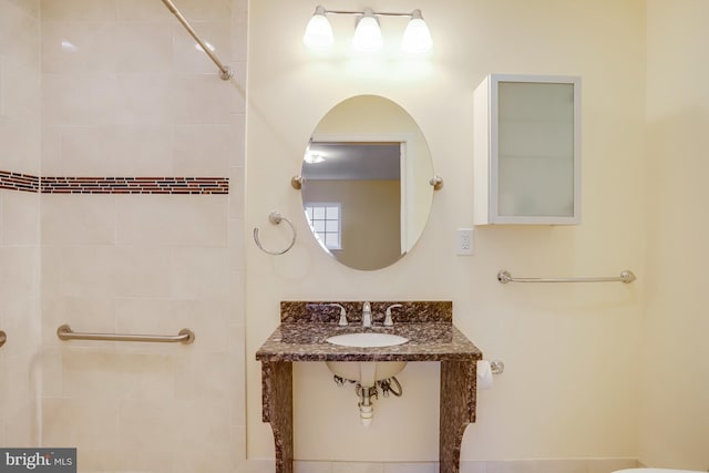 bathroom with a sink and tiled shower