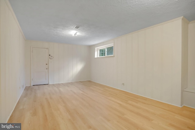 unfurnished room featuring light wood-type flooring and a textured ceiling