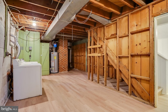 unfinished basement with independent washer and dryer, brick wall, light wood-style flooring, and water heater