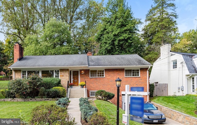 view of front of home with a front yard, brick siding, a chimney, and a shingled roof