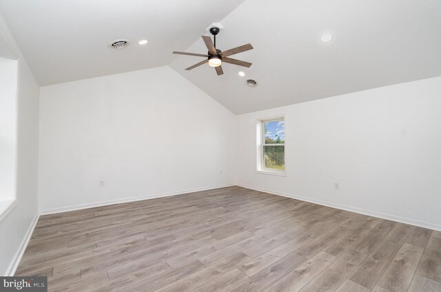 interior space featuring visible vents, a ceiling fan, vaulted ceiling, and light wood finished floors