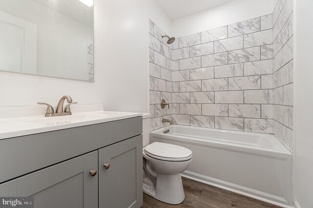 full bath with vanity, toilet, wood finished floors, and shower / bathtub combination