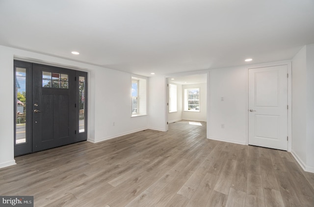 entryway with light wood-style flooring, recessed lighting, and baseboards