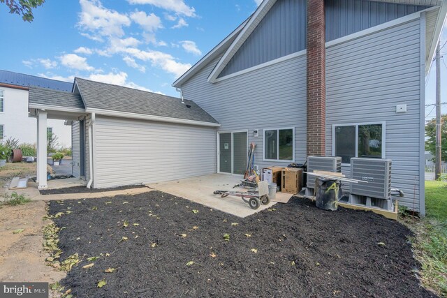 back of house featuring a shingled roof and a patio area