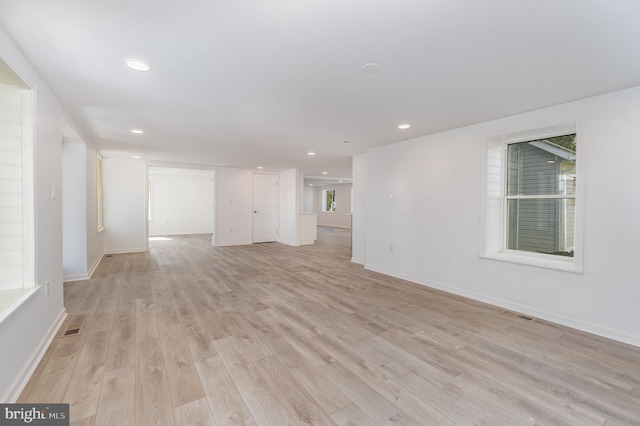 unfurnished room with light wood-type flooring, visible vents, baseboards, and recessed lighting