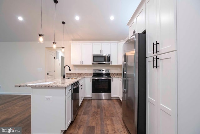 kitchen with hanging light fixtures, stainless steel appliances, sink, kitchen peninsula, and light stone counters