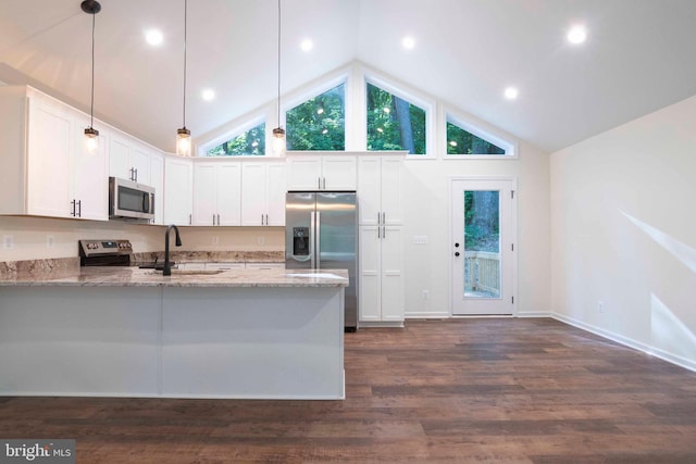 kitchen with white cabinets, appliances with stainless steel finishes, light stone countertops, and pendant lighting