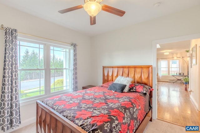 bedroom featuring multiple windows, ceiling fan, and light hardwood / wood-style floors