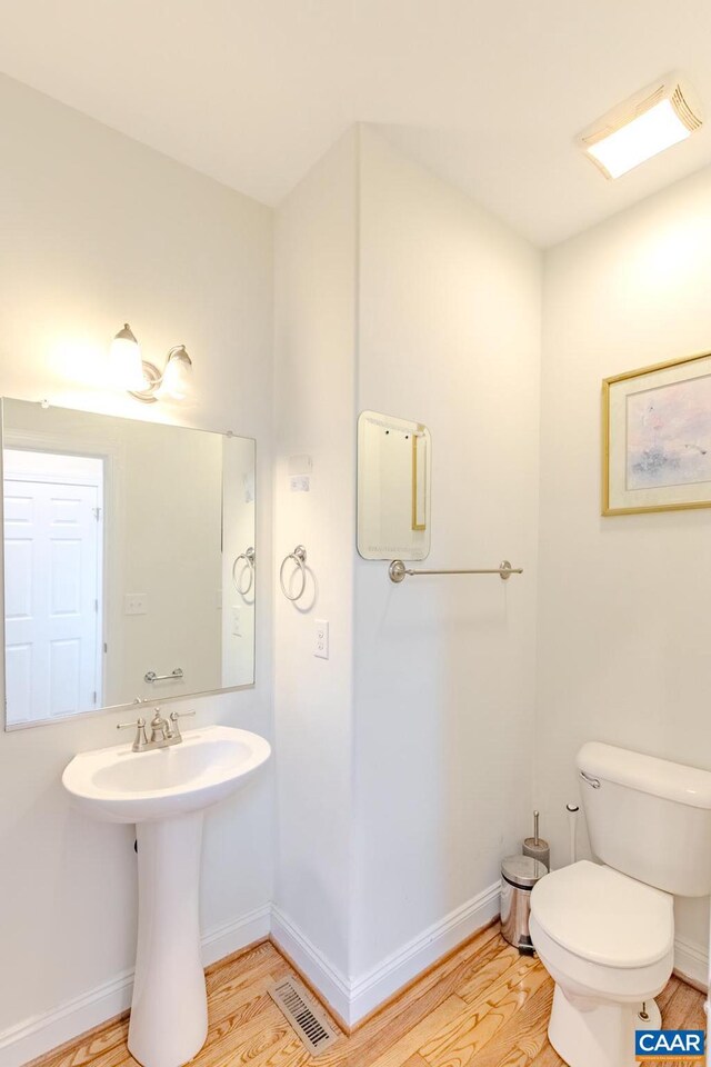 bathroom featuring hardwood / wood-style floors and toilet