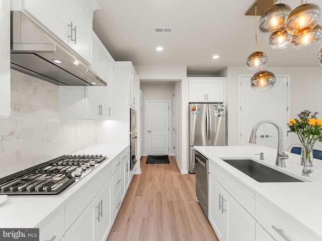 kitchen with visible vents, stainless steel appliances, under cabinet range hood, white cabinetry, and a sink