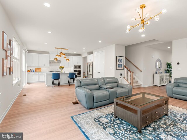 living room with light hardwood / wood-style flooring and a notable chandelier