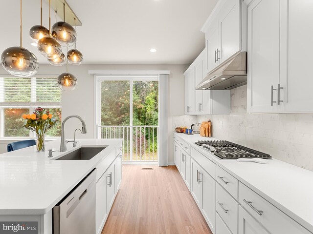 kitchen with a wealth of natural light, stainless steel appliances, a center island with sink, and sink