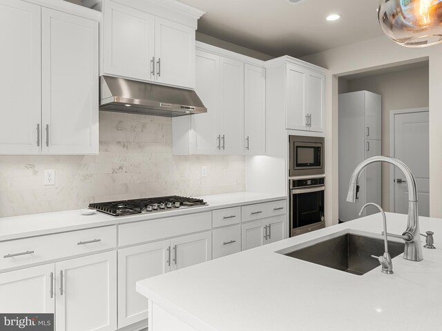 kitchen with backsplash, sink, appliances with stainless steel finishes, and white cabinets