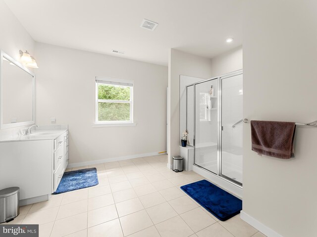 bathroom featuring tile patterned flooring, vanity, and a shower with shower door