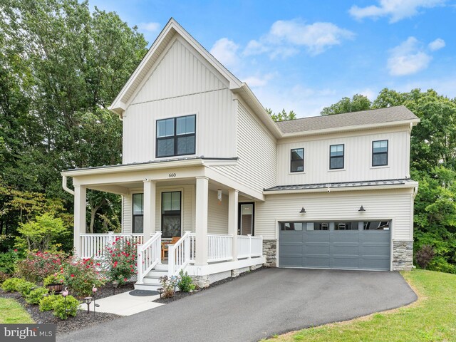 modern farmhouse featuring covered porch and a garage