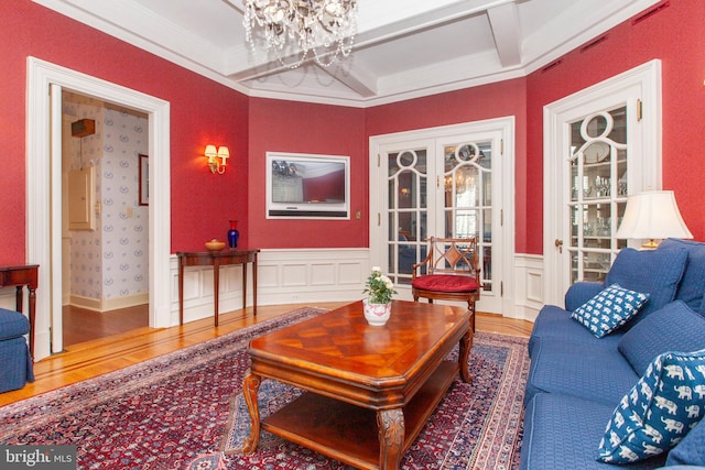 living room featuring crown molding, a chandelier, hardwood / wood-style floors, and beam ceiling