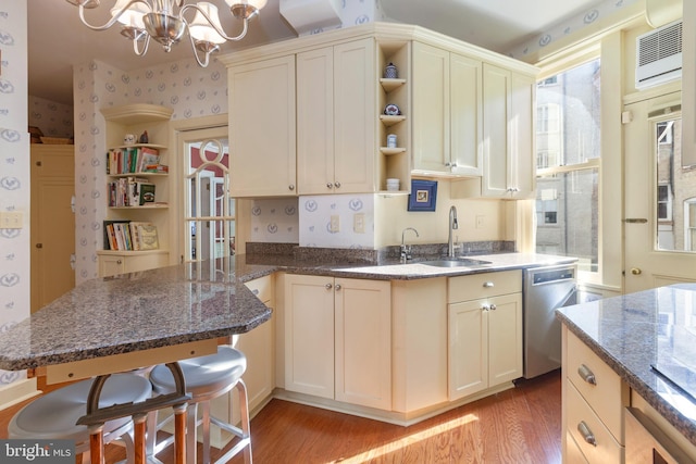 kitchen with dishwasher, open shelves, light wood finished floors, dark stone countertops, and wallpapered walls