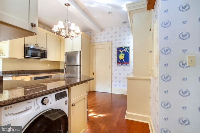 kitchen with beamed ceiling, washer / clothes dryer, dark wood-type flooring, stainless steel appliances, and a chandelier