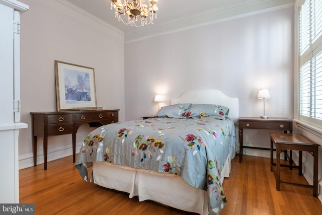 bedroom featuring a notable chandelier, wood-type flooring, and crown molding