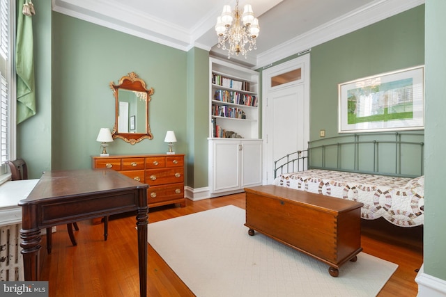 bedroom with crown molding, light hardwood / wood-style floors, and a notable chandelier