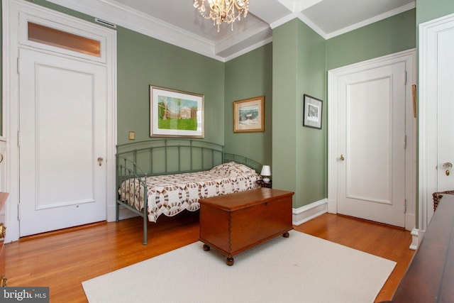 bedroom with ornamental molding, wood finished floors, and an inviting chandelier