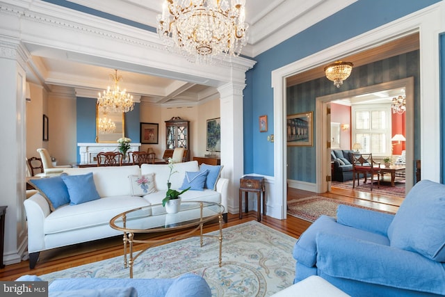 living area featuring wood finished floors, baseboards, beamed ceiling, decorative columns, and an inviting chandelier