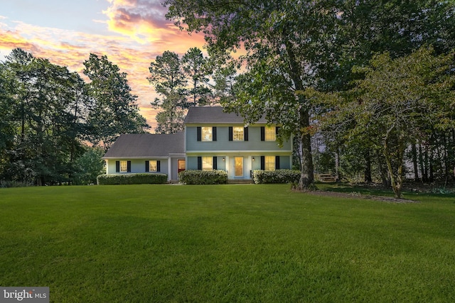 colonial inspired home with a lawn