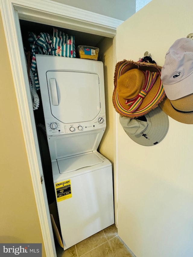 washroom with light tile patterned floors, laundry area, and stacked washer and clothes dryer