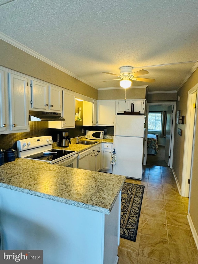 kitchen with under cabinet range hood, a peninsula, white appliances, white cabinetry, and ornamental molding