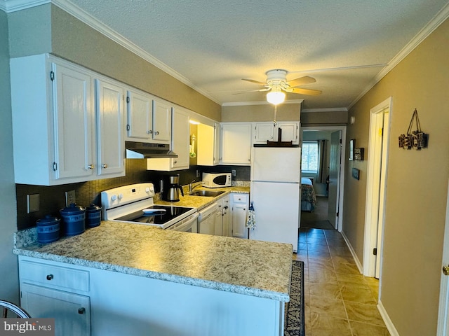 kitchen featuring under cabinet range hood, white appliances, a sink, white cabinetry, and crown molding