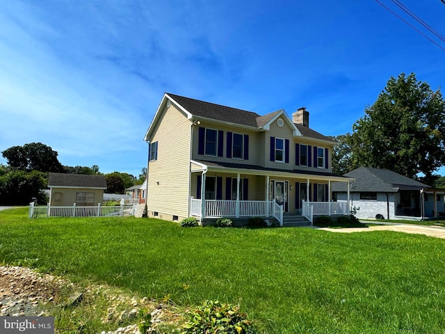 colonial house with covered porch, an outbuilding, and a front lawn