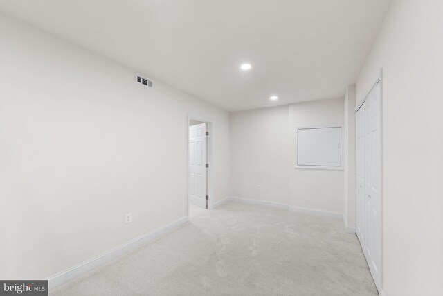 unfurnished bedroom with a closet and light colored carpet