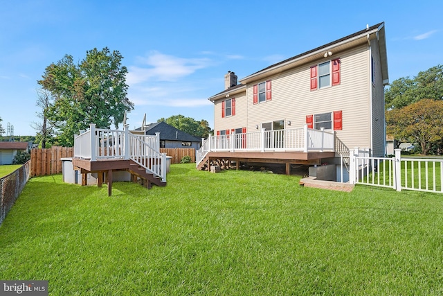 back of house featuring a wooden deck and a yard