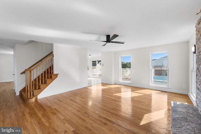 unfurnished living room featuring light hardwood / wood-style flooring and ceiling fan