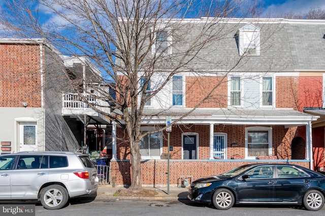 townhome / multi-family property with brick siding and roof with shingles