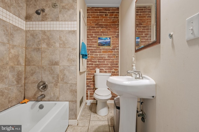 bathroom with toilet, washtub / shower combination, brick wall, and tile patterned flooring