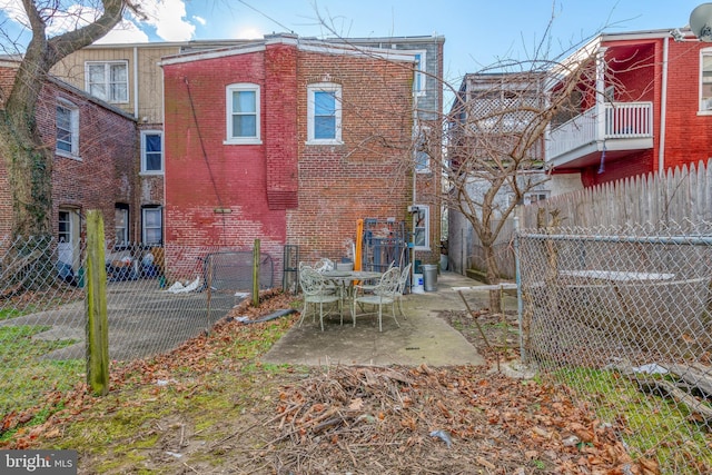 back of property featuring brick siding, a patio, and fence