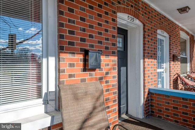 doorway to property featuring brick siding